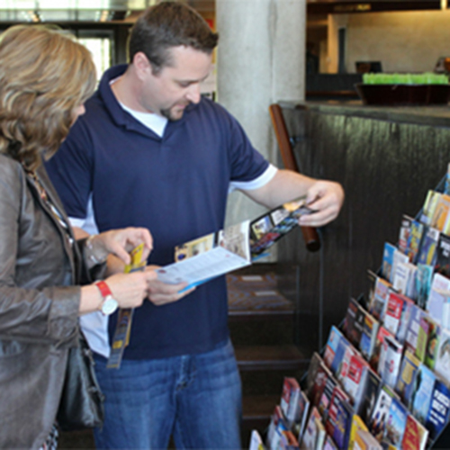 Couple flips through brochures in front of lobby display